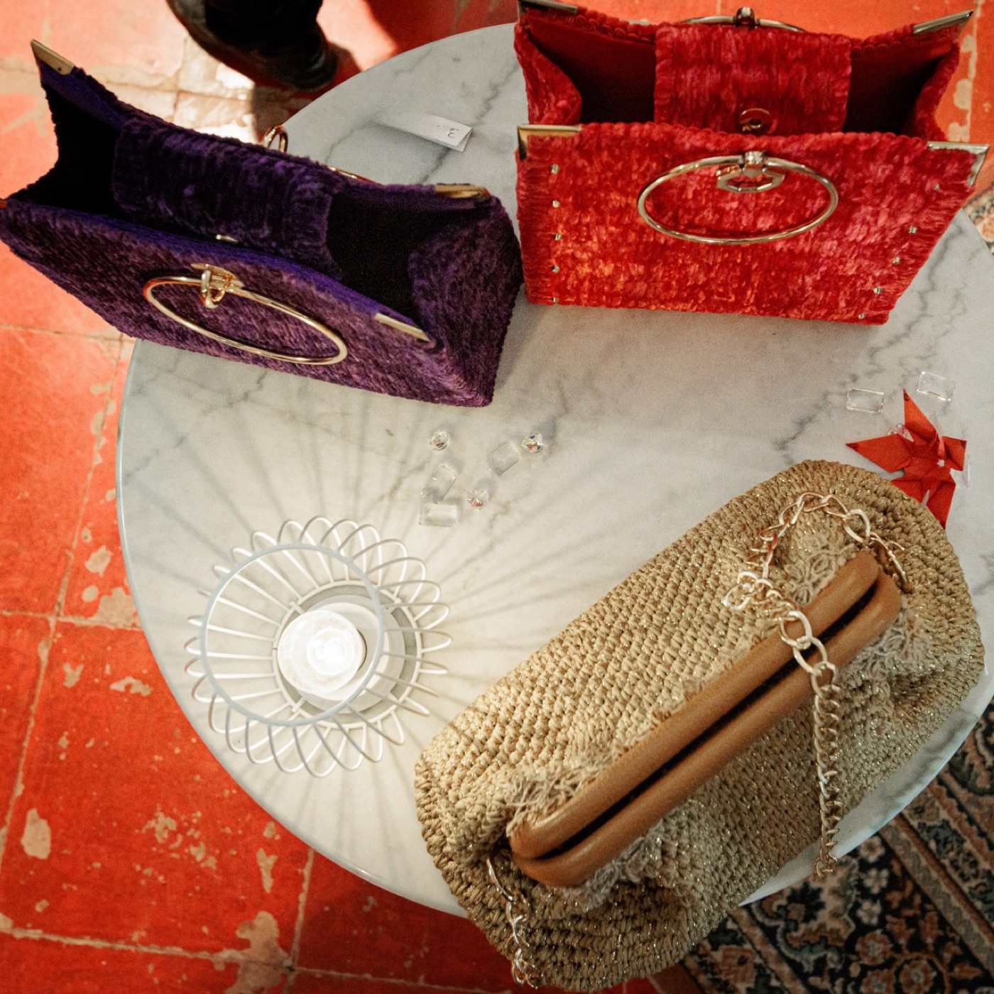 Evening creations in velvet and raffia, arranged on marble